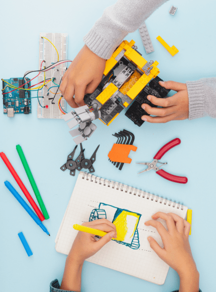 Children building a robot with tools and electronics during a hands-on STEM class.